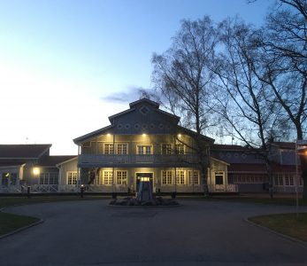 Villa Elban päärakennus iltavalaistuksessa.