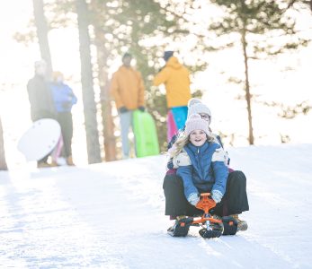 Lapsia ja nuoria pulkkamäessä.