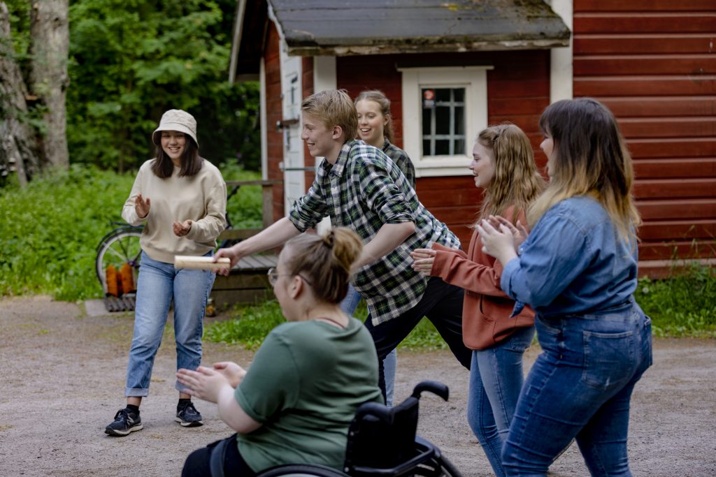 Joukko nuoria pelaamassa mölkkyä.