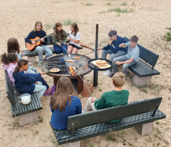 Kids on a bonfire on a beach.
