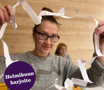 Nainen leikannut A4-paperiin aukin, josta mahtuu ihminen läpi.