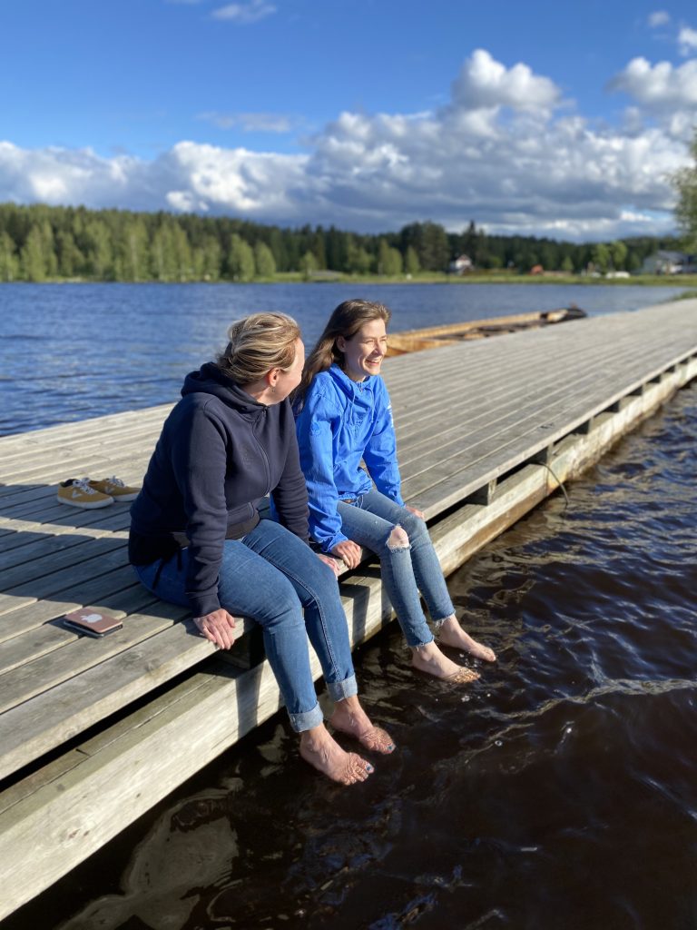 Kaksi henkilöä laiturilla Pielisen rannalla.