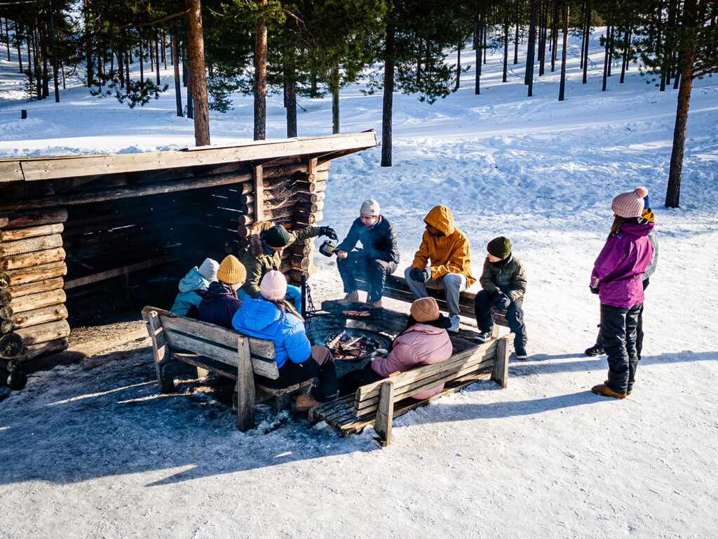 Lapsia ja nuoria luokkaretkellä talvella laavulla.