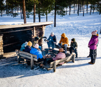 Lapsia ja nuoria luokkaretkellä talvella laavulla.