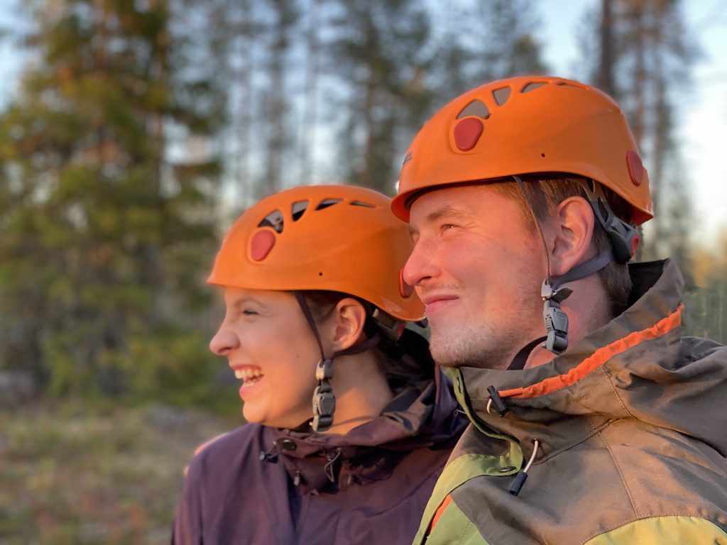 Mies ja nainen katsoo auringonlaskuun kiipeilykypärät päässä.