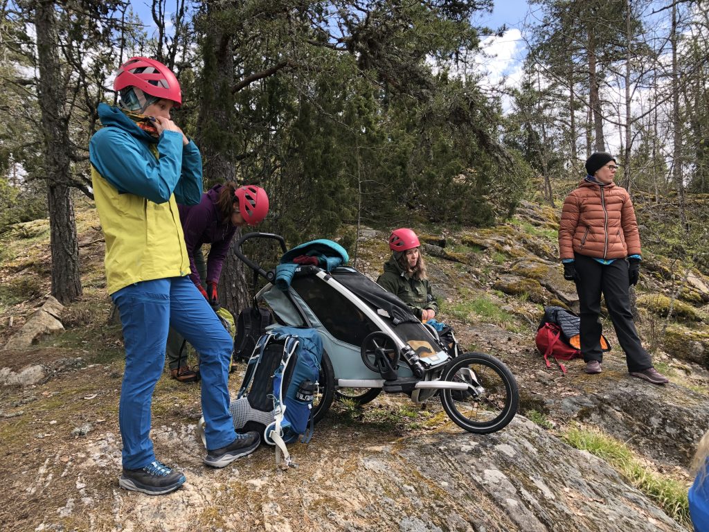 Seikkailijoita ja pieni lapsi kalliolla valmiina luolaseikkailuun.