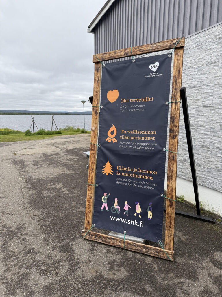 Purjekangas rakennuksen pihalla, jossa on nuorisokeskusten toimintaperiaatteet.