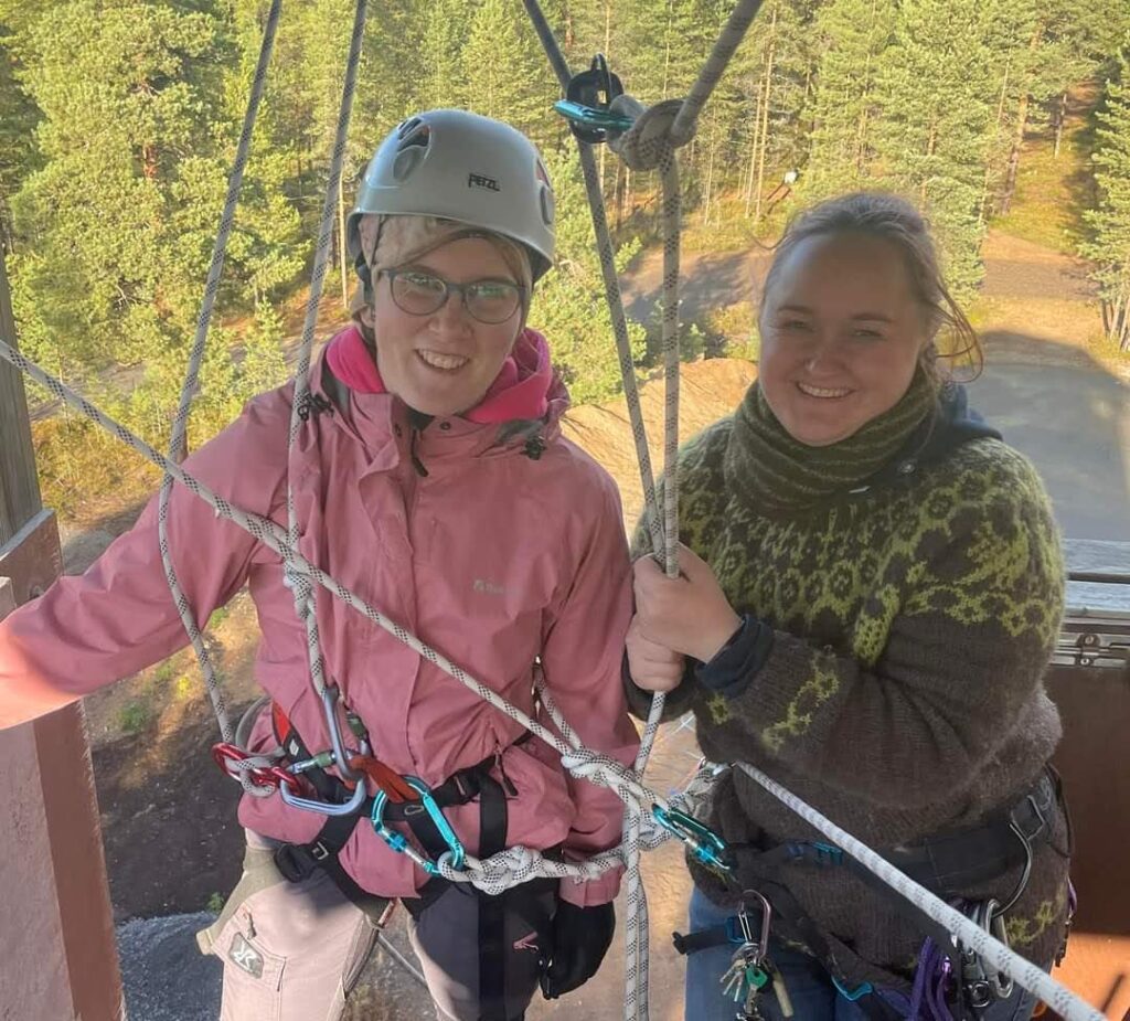 Nuotta-valmentaja ja ohjattava nuori laskeutumistornin huipulla.