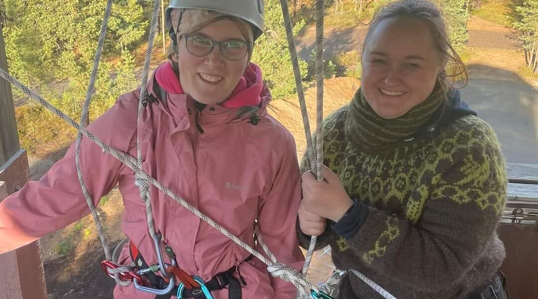 Nuotta-valmentaja ja ohjattava nuori laskeutumistornin huipulla.